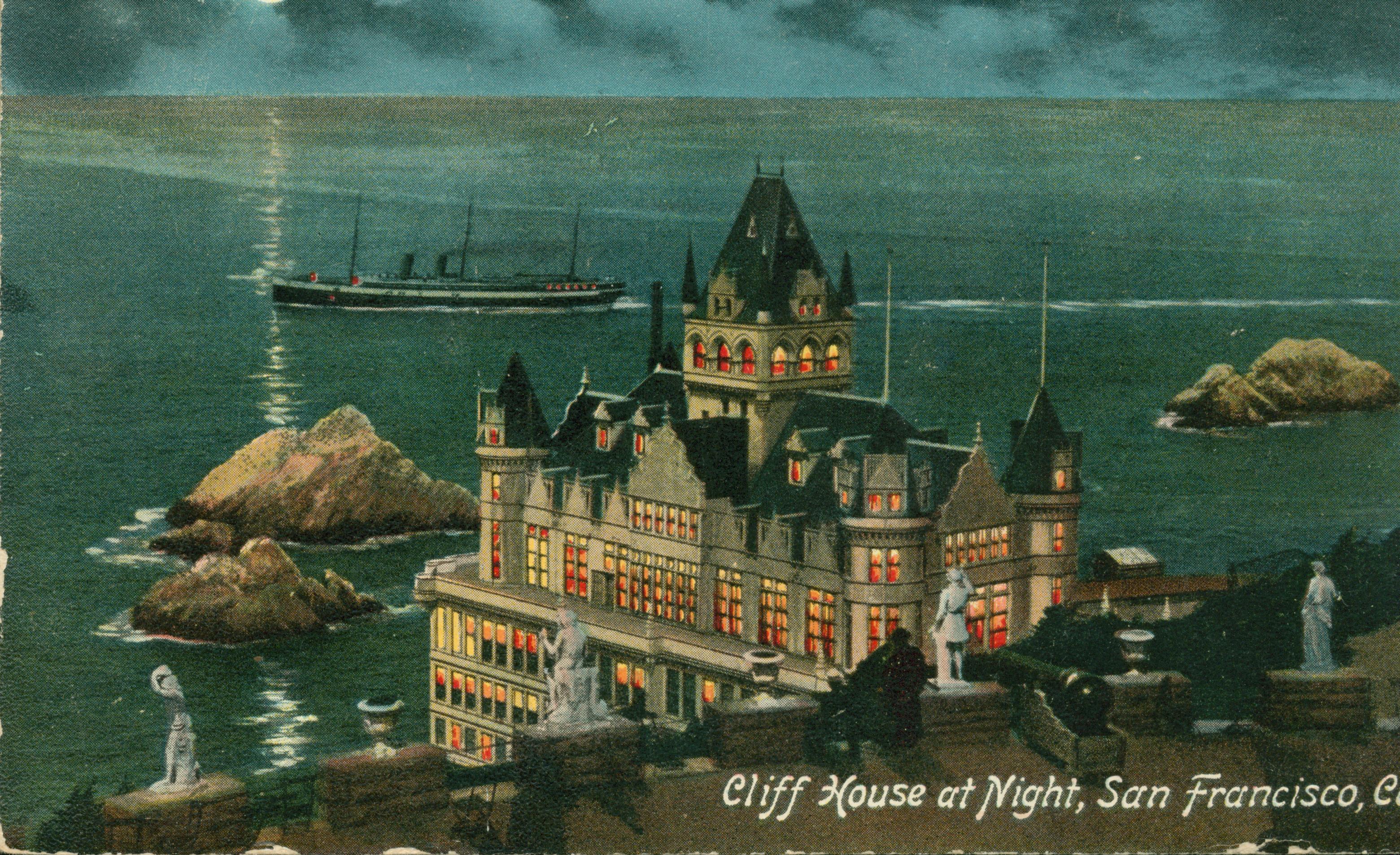 Shows the Cliff House and Seal Rocks at night, with the statues on Sutro Heights in the foreground.